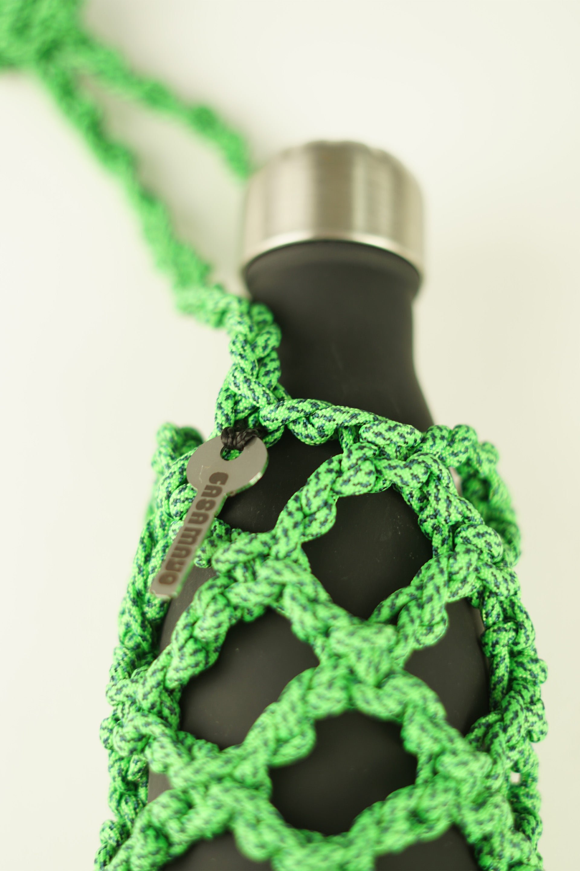 Green bottle carrier made of paracord rope