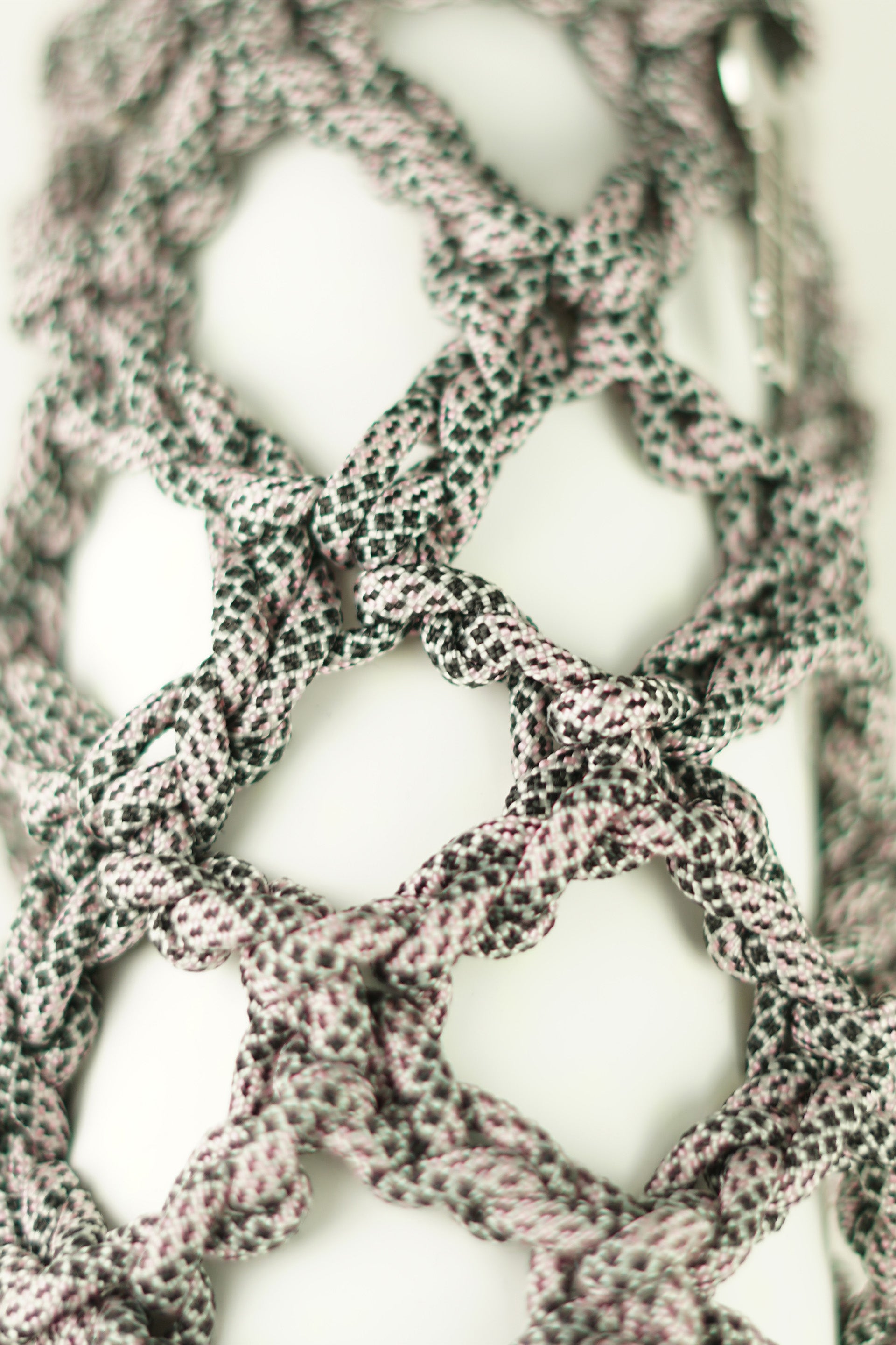 Black and white bottle porter made of paracord rope