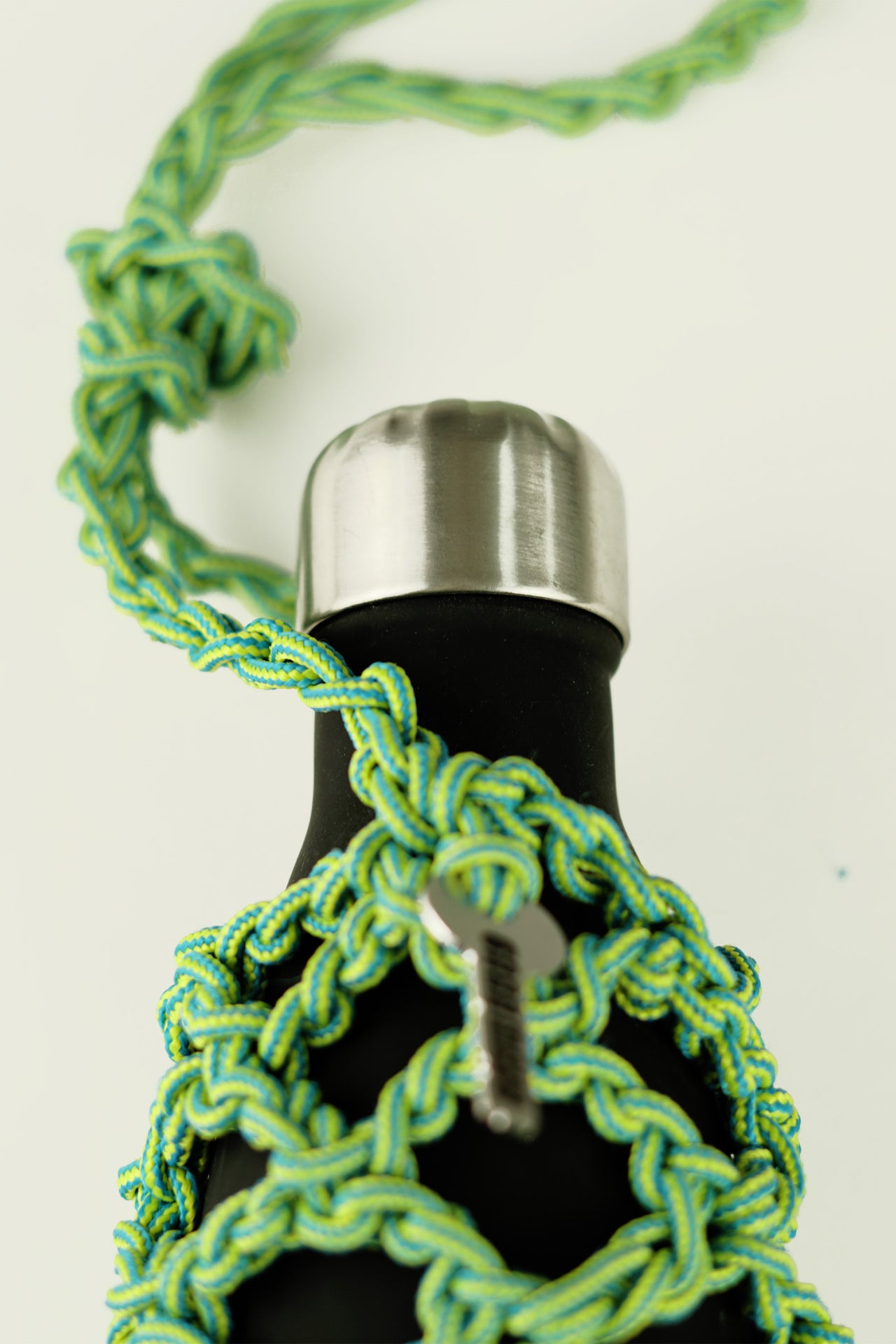Green and blue bottle porter made of paracord rope